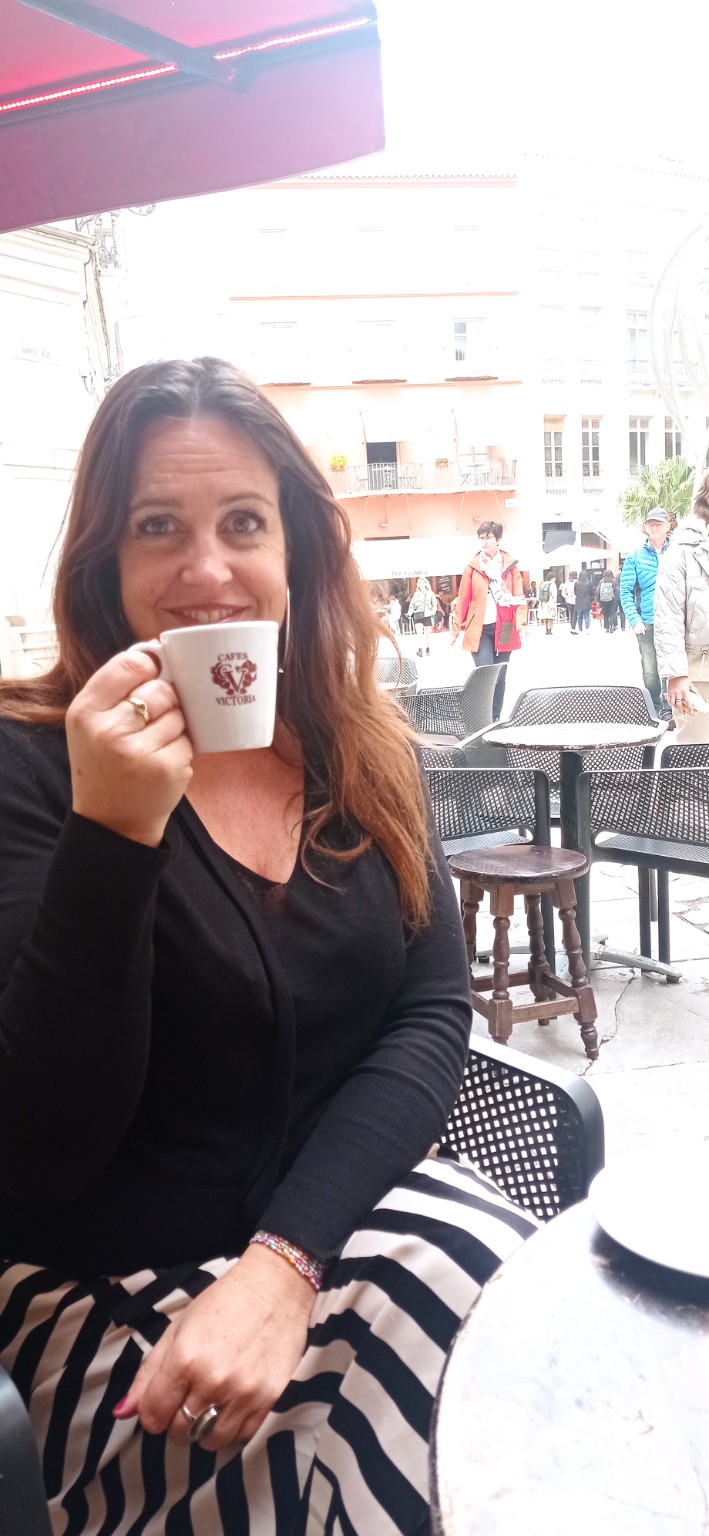 Persoon met koffie op een terras